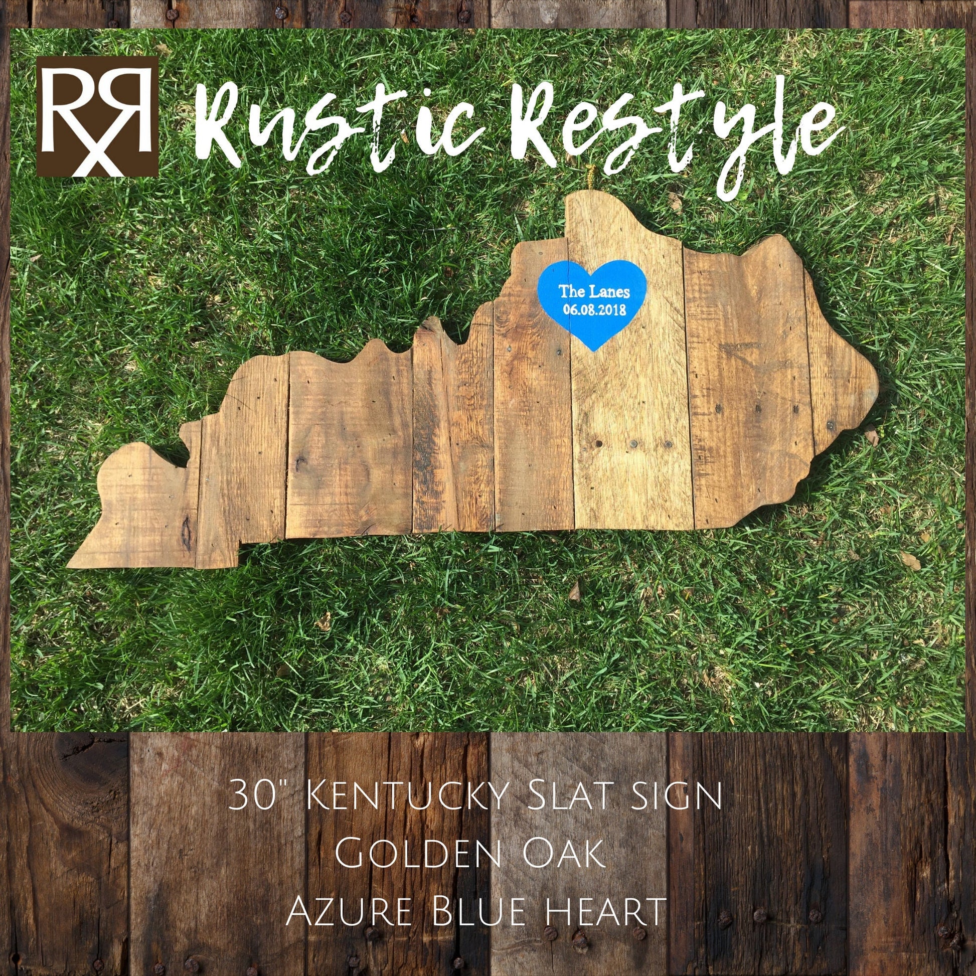 Kentucky-shaped wood sign laying flat in the grass. vertical wood slats with nail holes showing. A Blue heart is painted near the top center with the name The Lees and date painted on it.