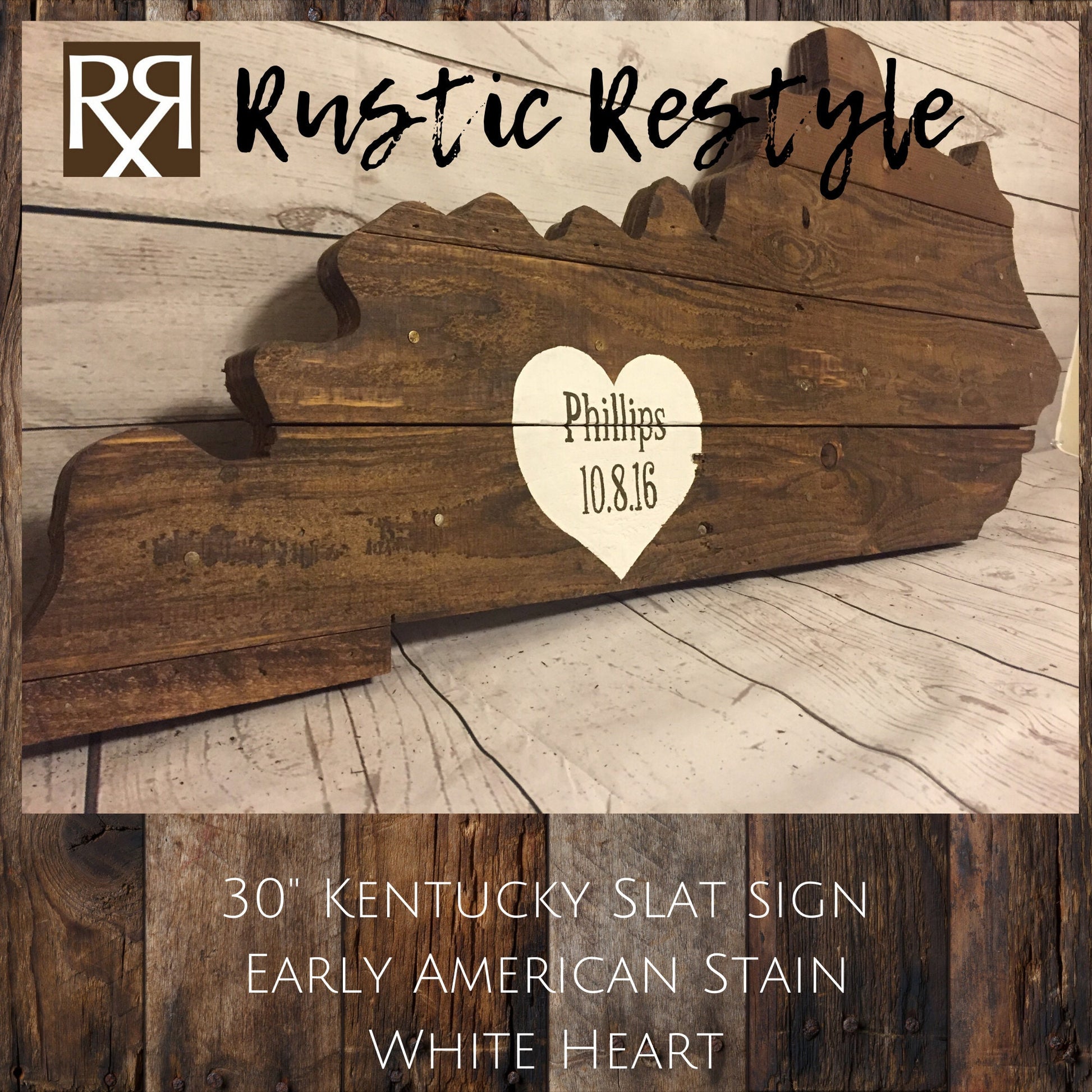 Kentucky-shaped wood sign leaning up against a faux white wood wall. Horizontal wood slats with nail holes showing. A White heart is painted near the lower left with the name Phillips and date painted on it.