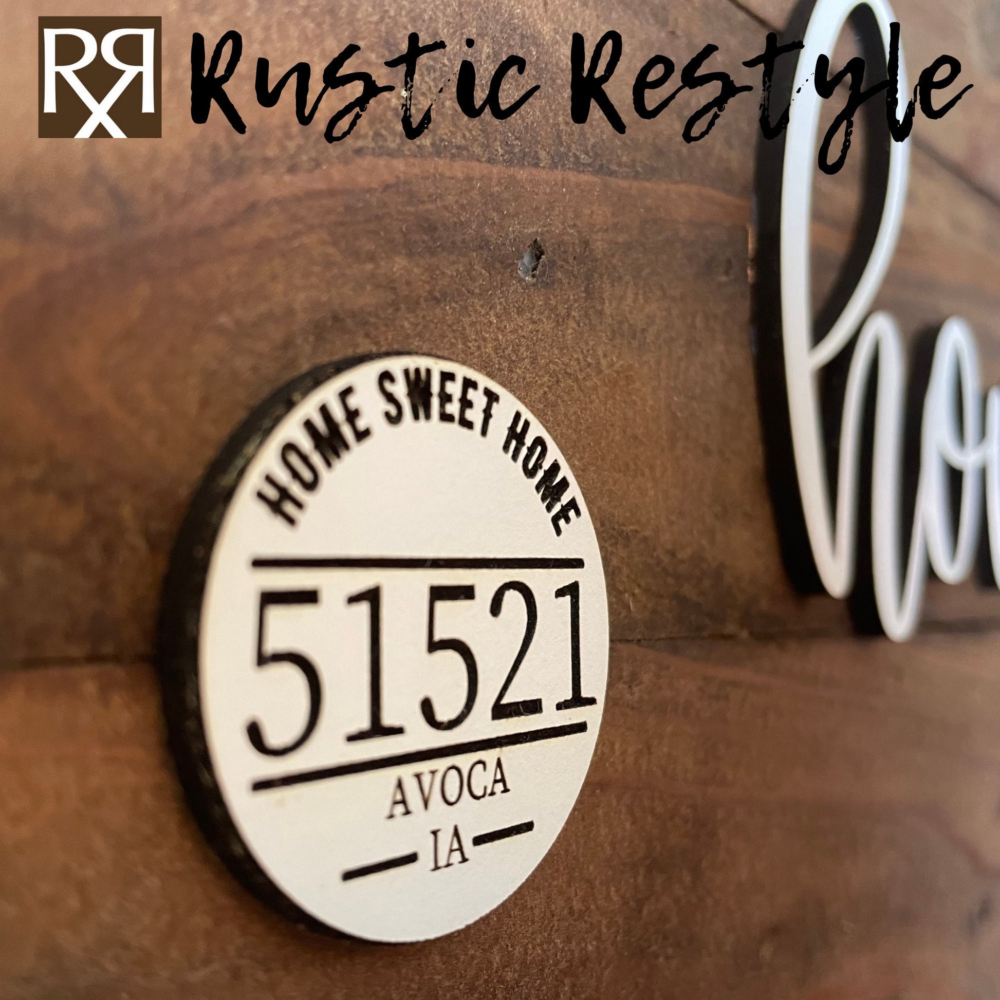 Close-up View Wooden Iowa shape sign, The word home is across the middle in white. There is a small white wooden disc on the left middle with home sweet home, 51521 zip code and Avoca engraved on it.