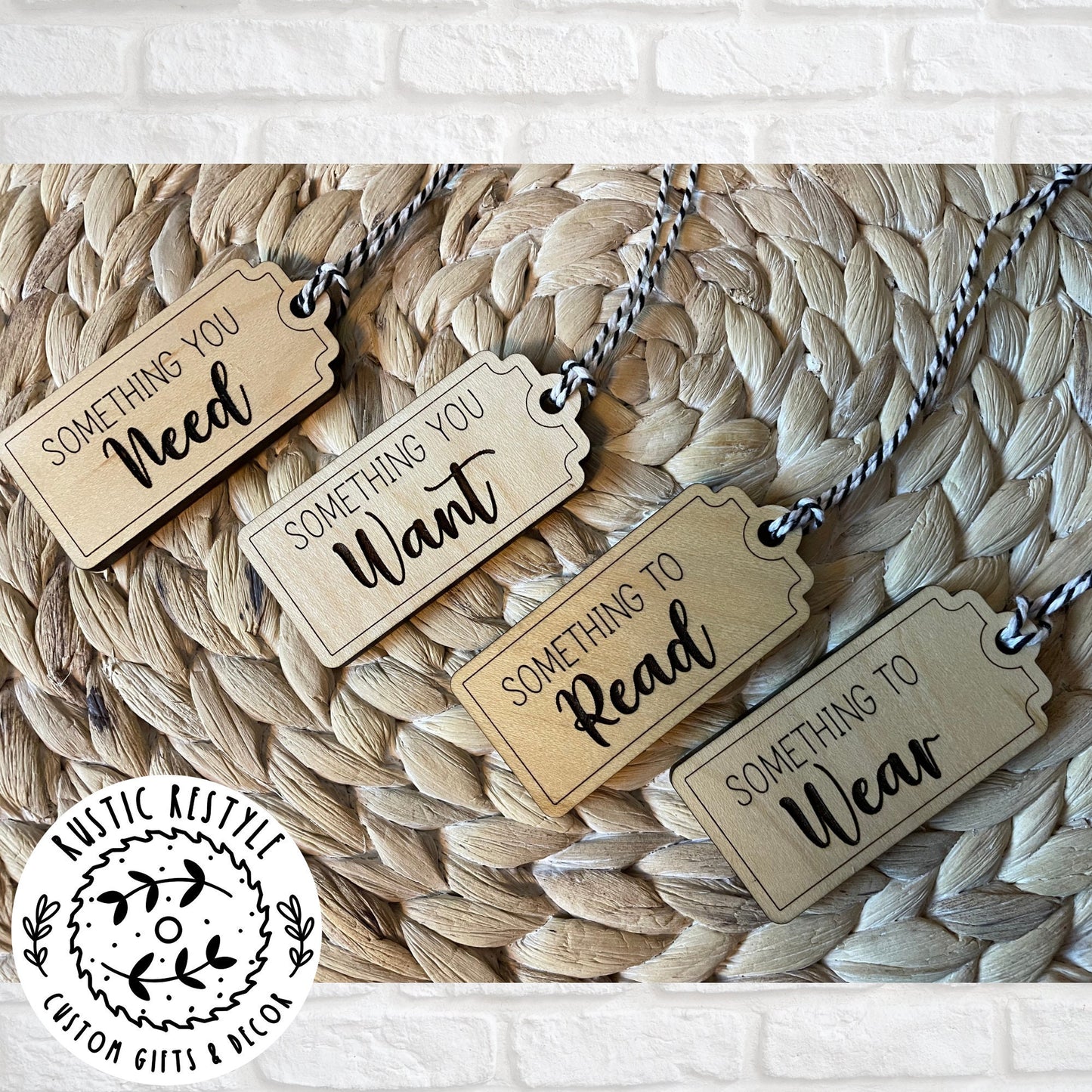 4 Christmas gift tags laying on a woven placemat. First tag says Something you Need. Second tag says Something you Want. Third tag says Something you Read and the last tag says something you Wear. Each tag has a black and white bakers twine string.