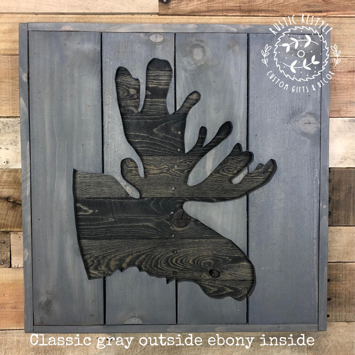 A wooden sign with a silhouette of a moose's head, featuring a classic gray color scheme and an elegant design.