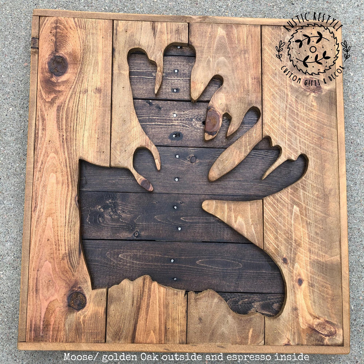 a wooden cutout of a moose head, with the moose's golden oak head visible inside the cutout.