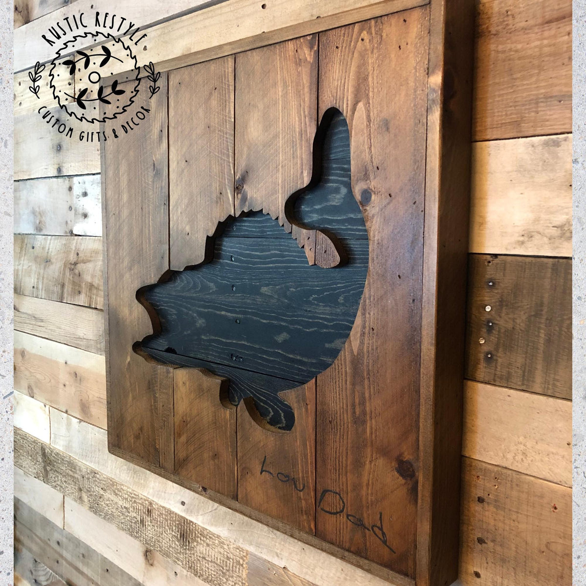a wooden wall with a cutout of a fish, which appears to be a carved piece of wood.