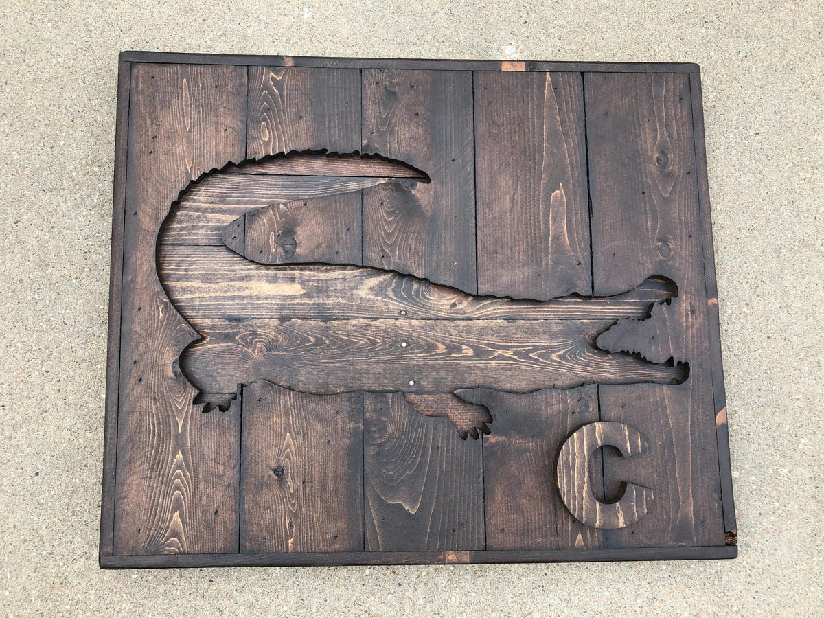 a wooden cutout of a crocodile, with the letter 'C' on it.