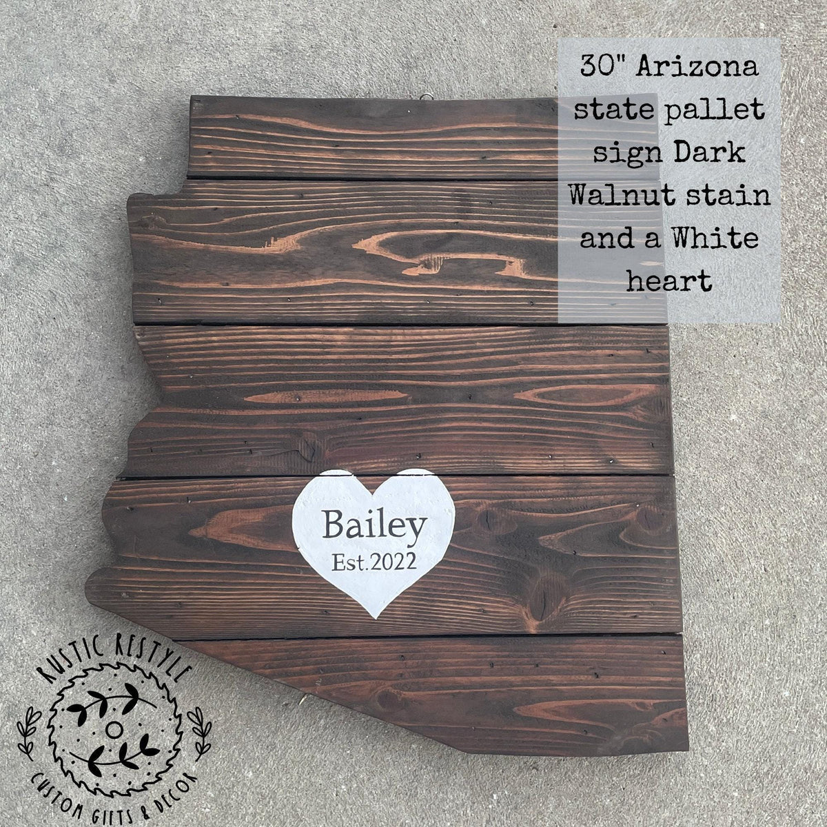The image is a wooden sign depicting the state of Arizona, with a heart-shaped cutout in the center displaying the name "Baley" and the year "Est. 2020".