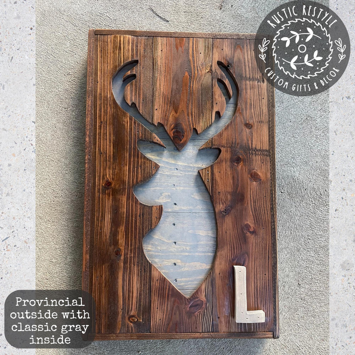 a wooden sign with a cutout of a deer head and the letter "L" inside it.