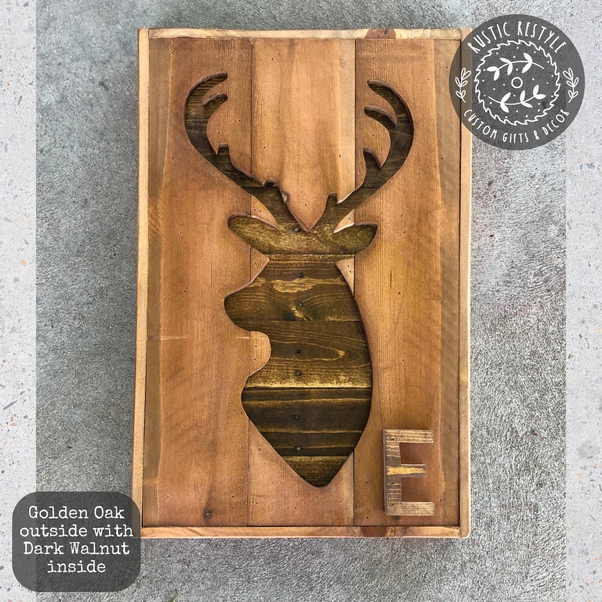 a wooden deer head cut out from a wooden board, with the letter "E" carved into it.