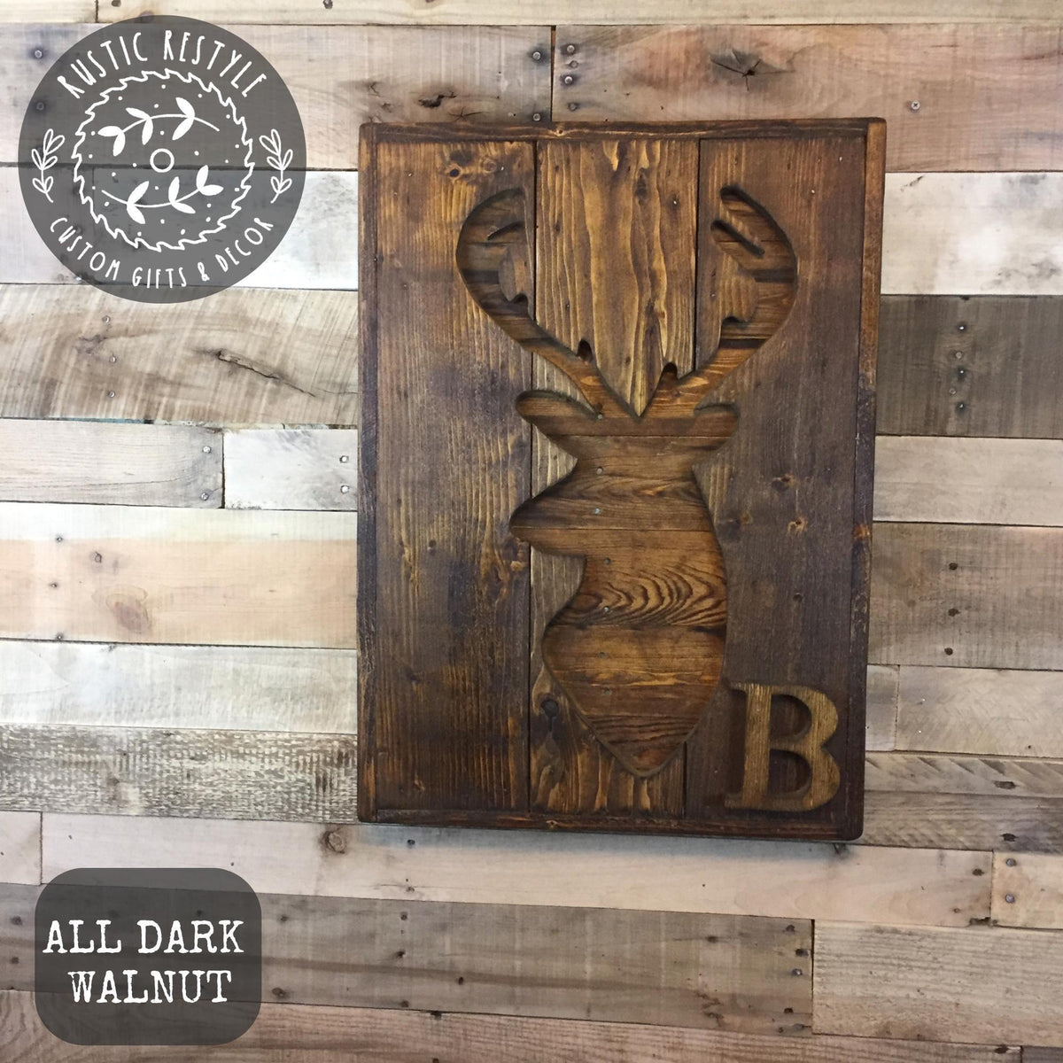 a wooden plaque with a carved deer head and the letter "B" on it, mounted on a wooden wall.