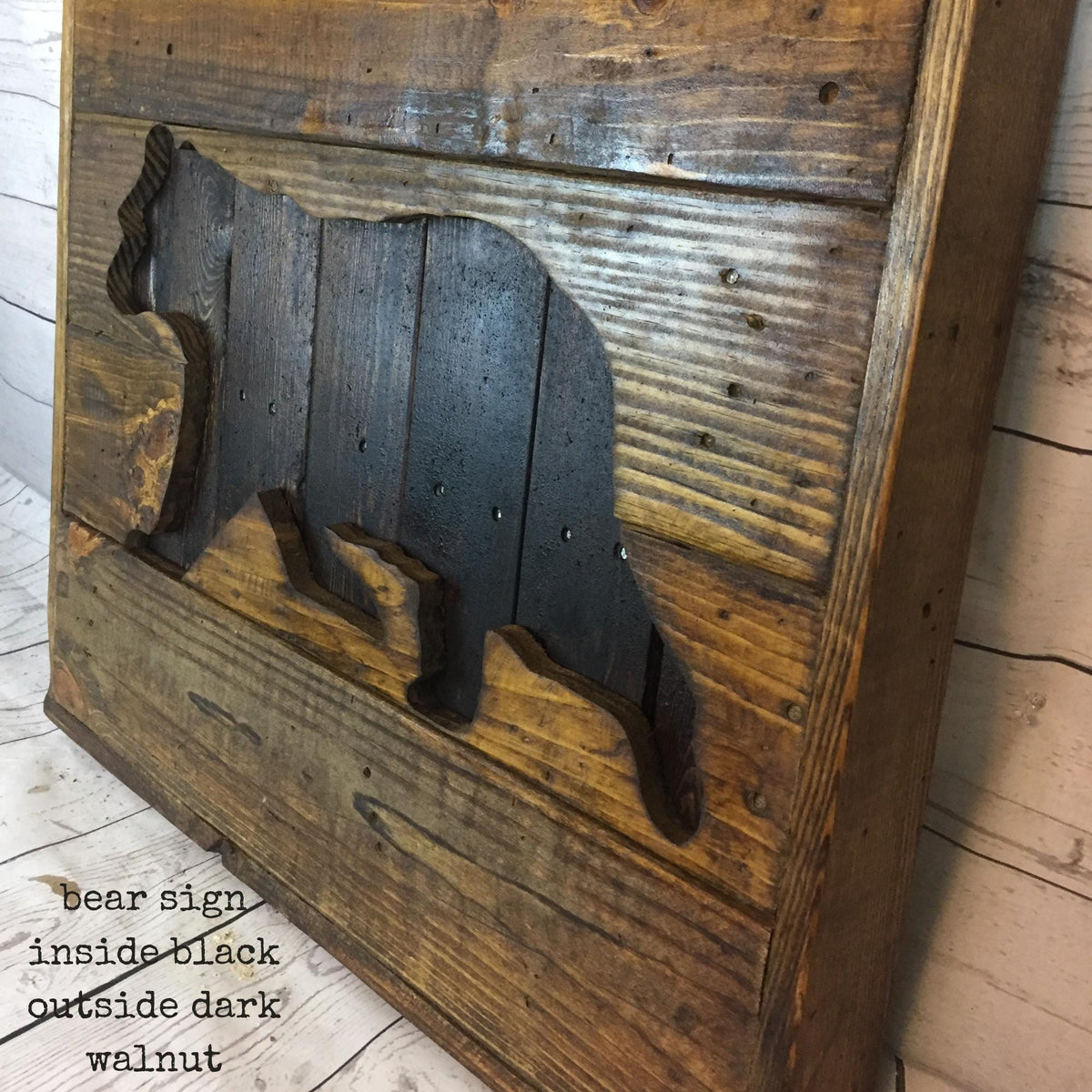 a wooden sign with a silhouette of a bear carved into it.
