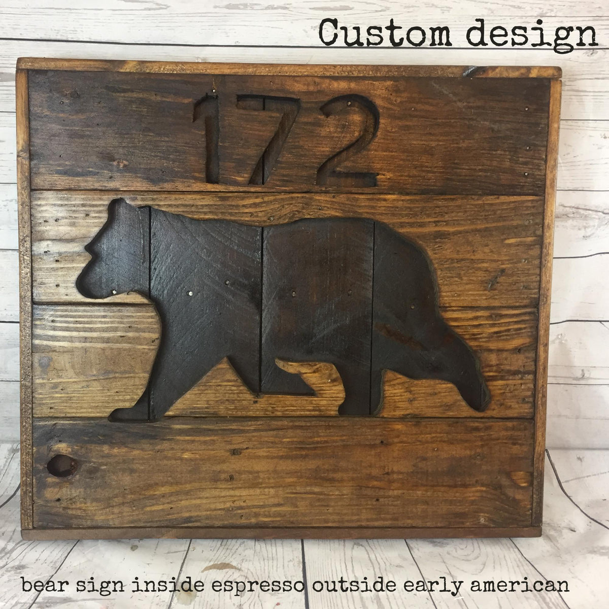 a wooden sign with a bear silhouette, and the number "172" carved into it. The sign is made of wooden planks and has a rustic, natural appearance.