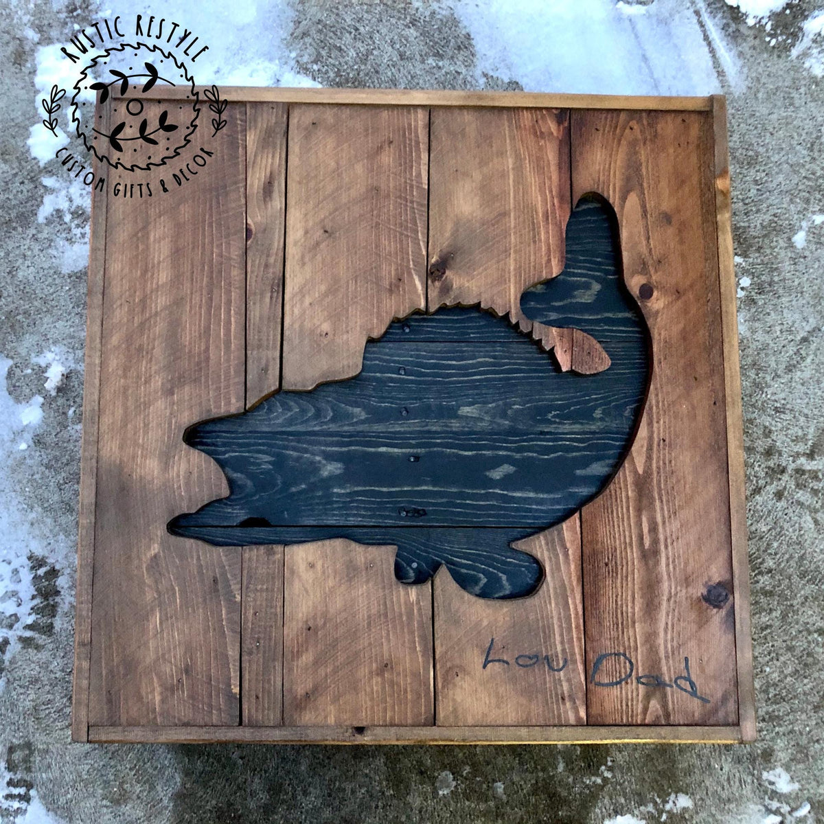 a wooden board with a silhouette of a fish cut out, and there is a handwritten message on the board.