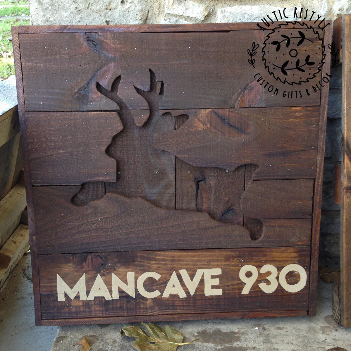 A wooden sign with a carved jackalope silhouette and the text "MANCAVE 930" on it.