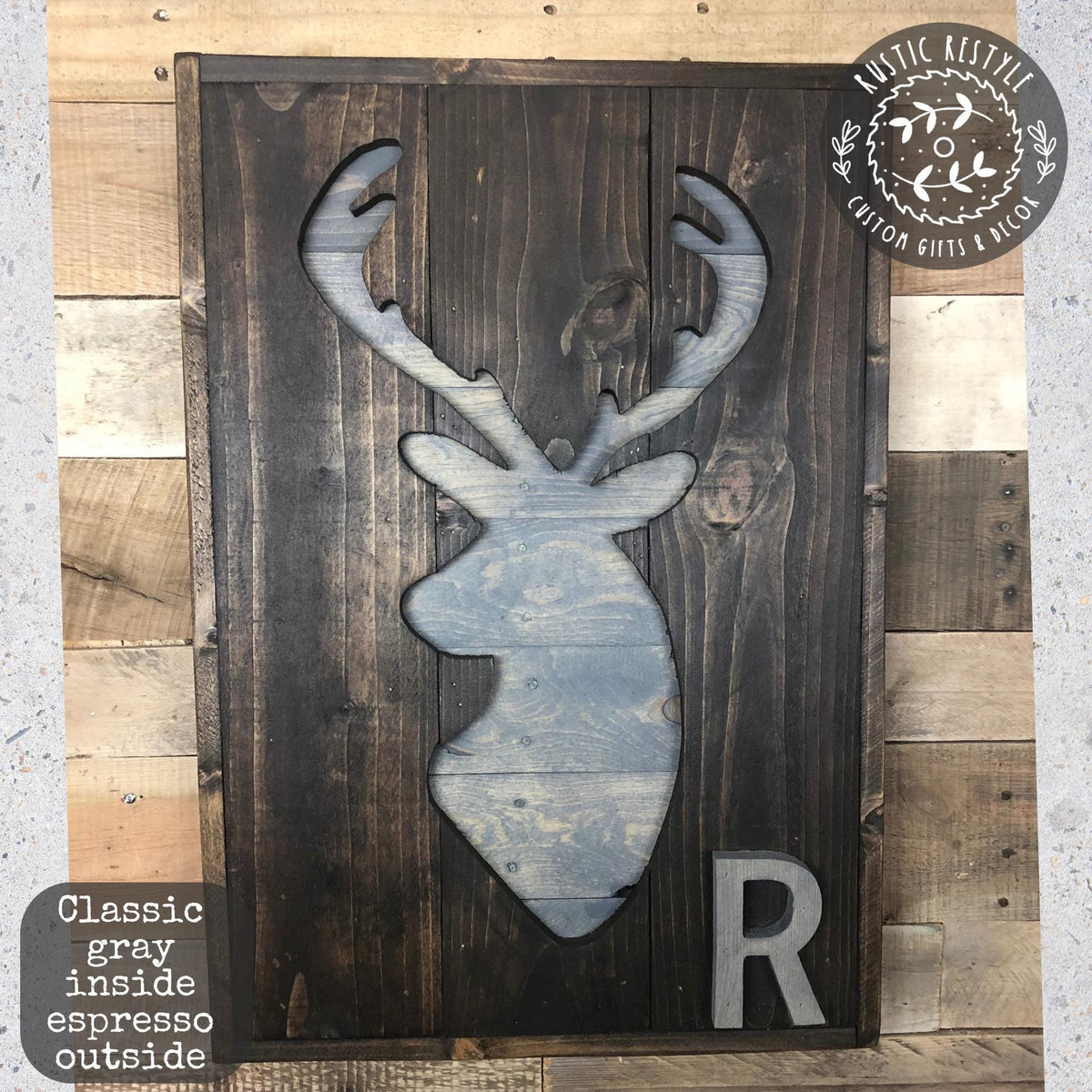 a wooden sign with a deer head silhouette and the letter "R" below it.