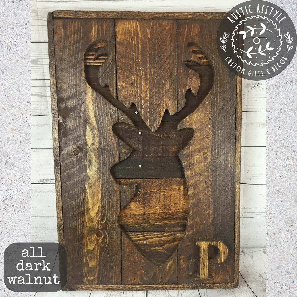 A wooden sign featuring a carved deer head silhouette.