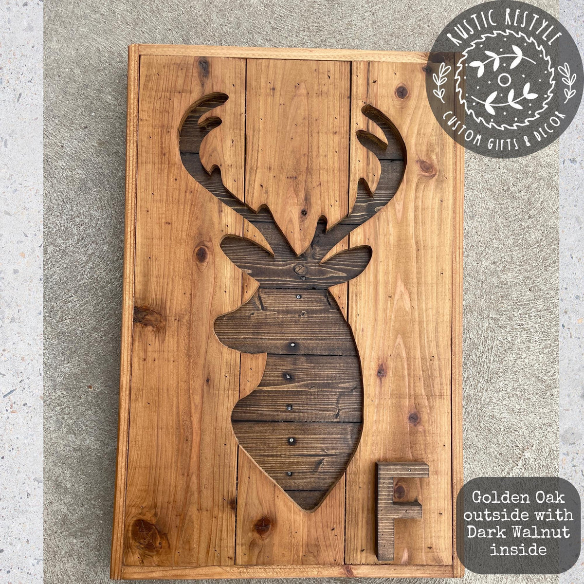 a wooden deer head cut out of a wooden board, with the letter "F" below it.