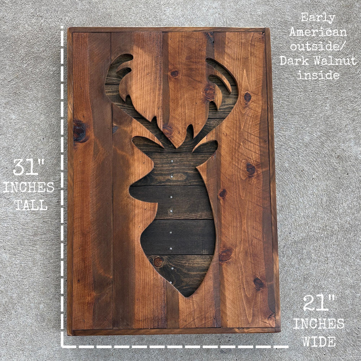 a wooden deer head cutout with antlers, placed on a wooden surface.