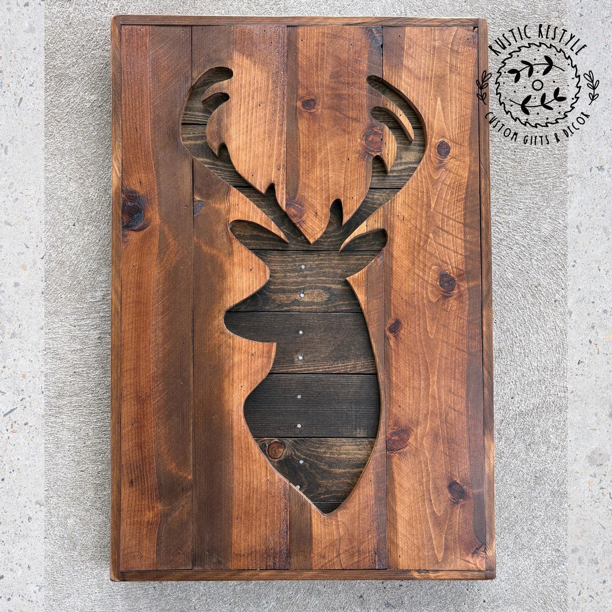 a wooden board with a cutout of a deer head, which appears to be a decorative piece.